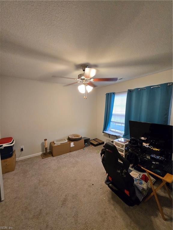 interior space with ceiling fan, carpet flooring, and a textured ceiling