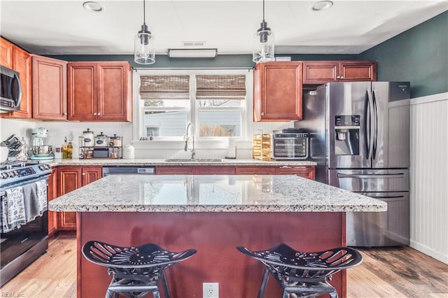 kitchen with pendant lighting, appliances with stainless steel finishes, and a kitchen island