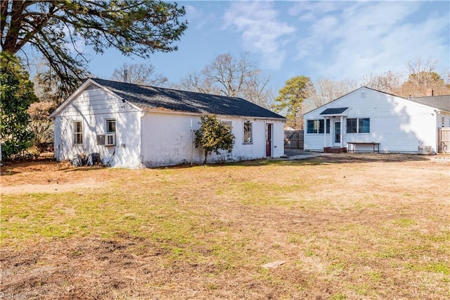 rear view of property featuring a lawn