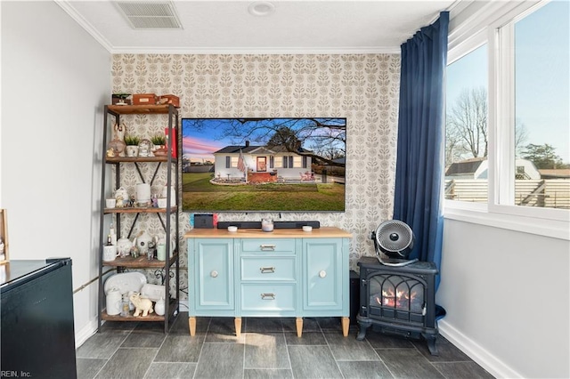 interior space featuring crown molding and a wood stove