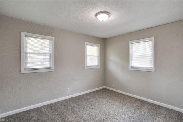 carpeted spare room with a textured ceiling