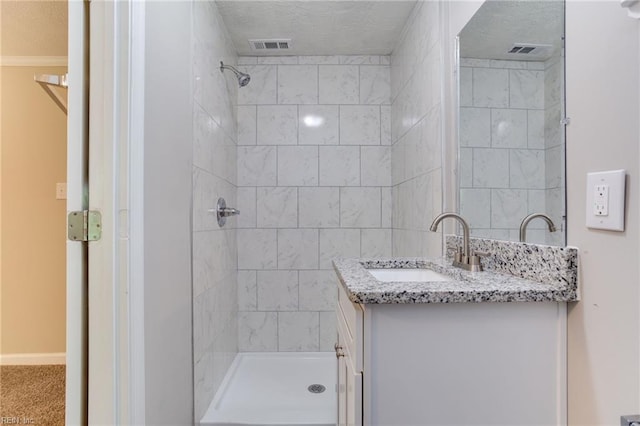 bathroom with vanity and a tile shower