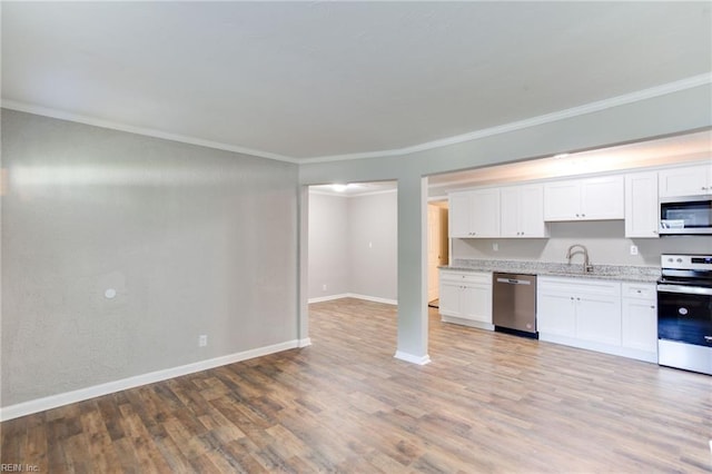 kitchen featuring sink, crown molding, light wood-type flooring, appliances with stainless steel finishes, and white cabinets