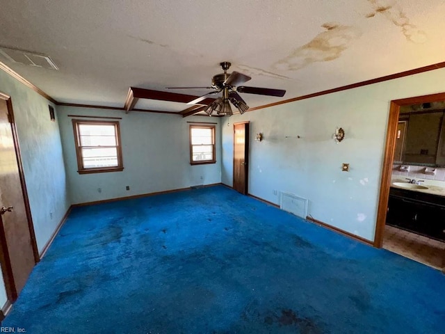 carpeted spare room featuring crown molding, ceiling fan, and sink