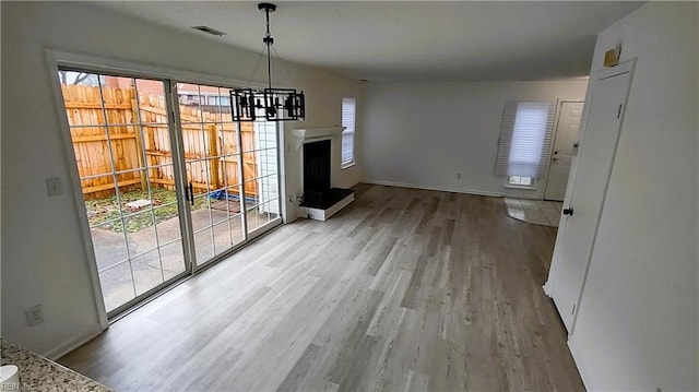 unfurnished dining area featuring hardwood / wood-style floors and a notable chandelier