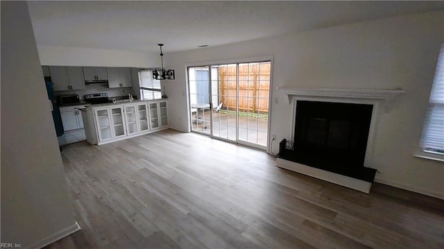 interior space with light hardwood / wood-style flooring, a chandelier, and refrigerator