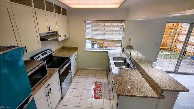 kitchen featuring light tile patterned flooring, appliances with stainless steel finishes, stone countertops, sink, and white cabinets