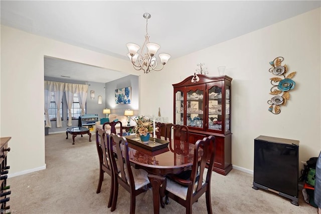 carpeted dining space with a chandelier