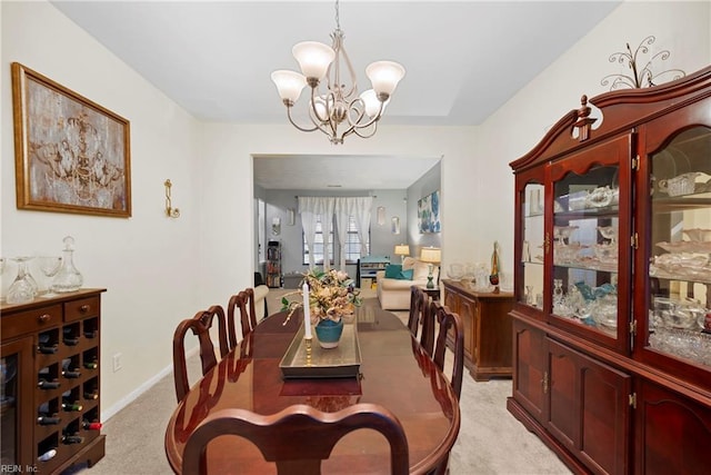 carpeted dining area featuring a chandelier