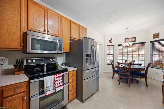 kitchen with stainless steel appliances, a notable chandelier, and decorative light fixtures