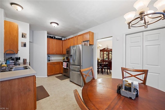 kitchen with sink, a notable chandelier, and stainless steel appliances