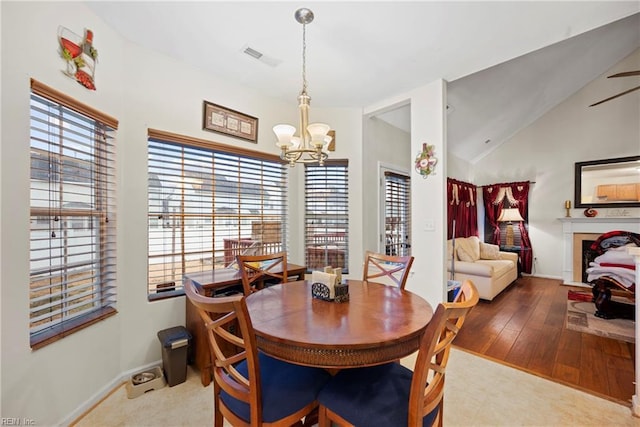 dining area with ceiling fan with notable chandelier and vaulted ceiling