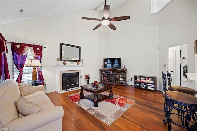 living room featuring beam ceiling, ceiling fan, hardwood / wood-style floors, and high vaulted ceiling