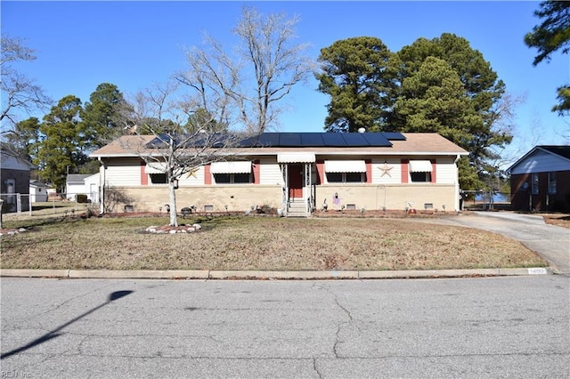 view of front facade with a front yard and solar panels