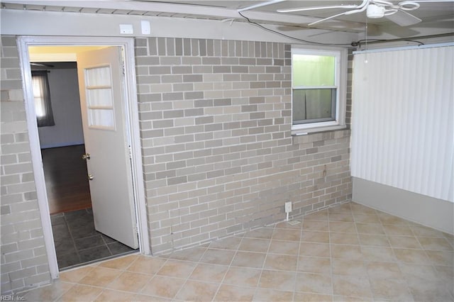 interior space featuring tile patterned flooring and brick wall