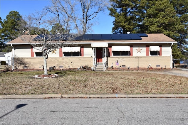 view of front facade with a front yard and solar panels