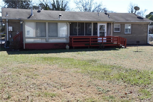 rear view of house featuring a lawn and a sunroom