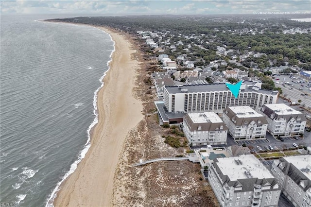 birds eye view of property with a water view and a beach view