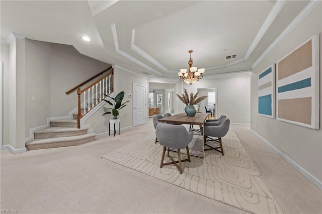 dining room featuring ornamental molding, light colored carpet, a notable chandelier, and a tray ceiling