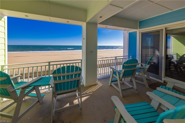 balcony with a water view and a beach view