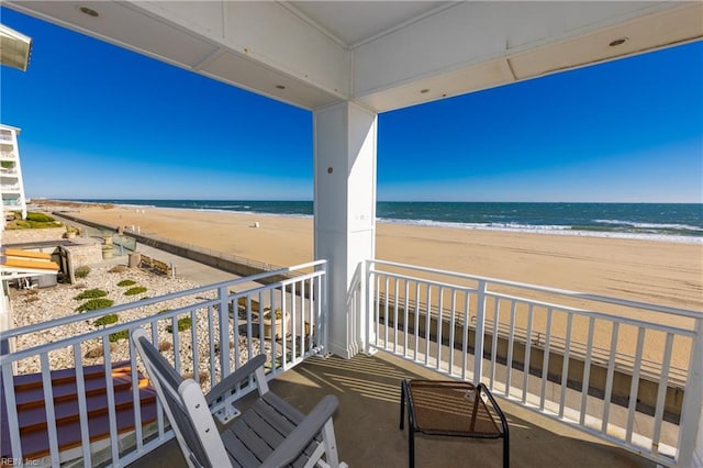 balcony featuring a water view and a beach view