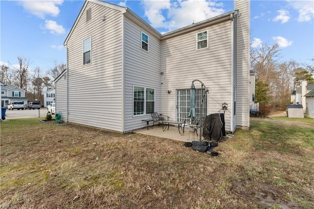 back of house featuring a patio area and a lawn