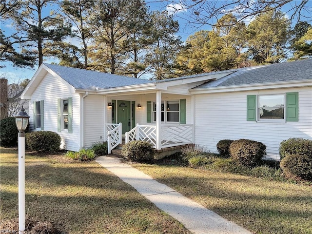 single story home featuring covered porch and a front yard