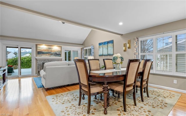 dining room featuring lofted ceiling and light hardwood / wood-style flooring