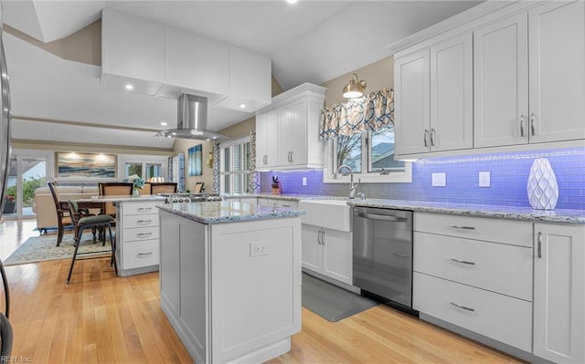 kitchen with sink, island range hood, white cabinets, a kitchen island, and stainless steel dishwasher