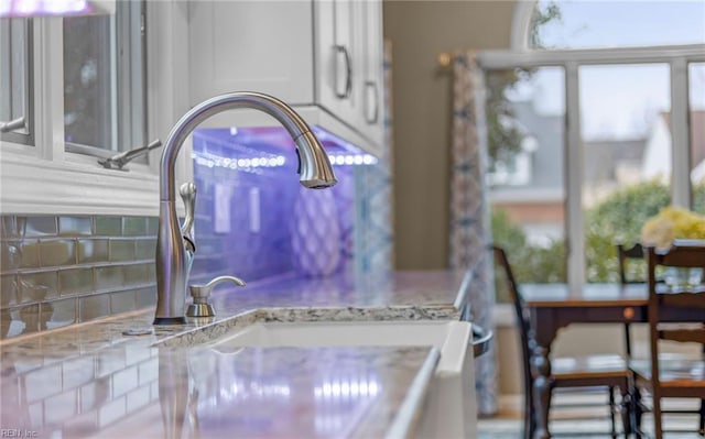 details featuring light stone counters and white cabinets