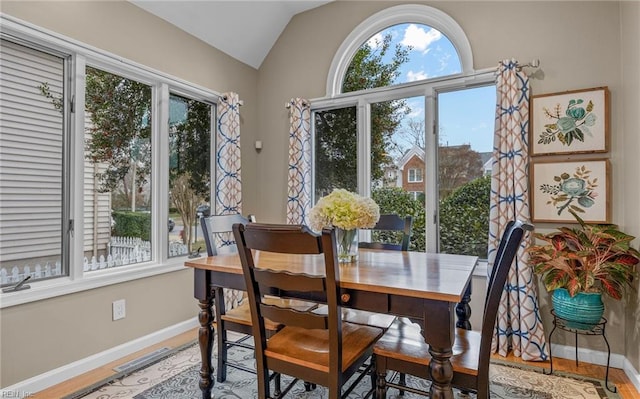 dining area featuring vaulted ceiling and hardwood / wood-style floors