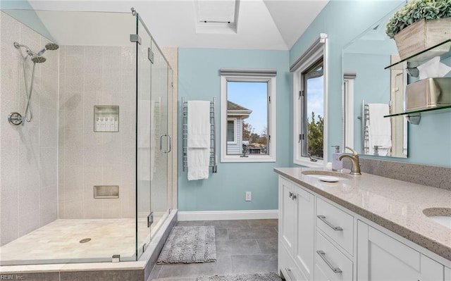 bathroom featuring vanity, a shower with shower door, and vaulted ceiling