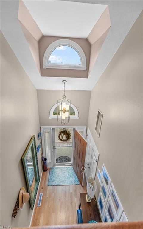 entryway featuring a chandelier, hardwood / wood-style floors, and high vaulted ceiling