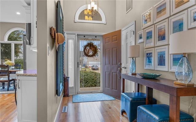 foyer with light hardwood / wood-style flooring and a high ceiling