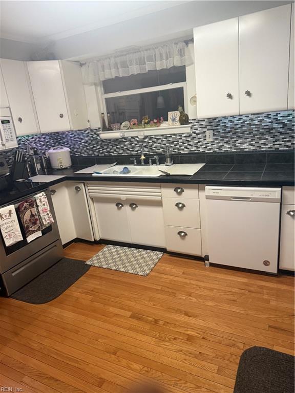 kitchen with sink, white cabinetry, light hardwood / wood-style flooring, white appliances, and decorative backsplash