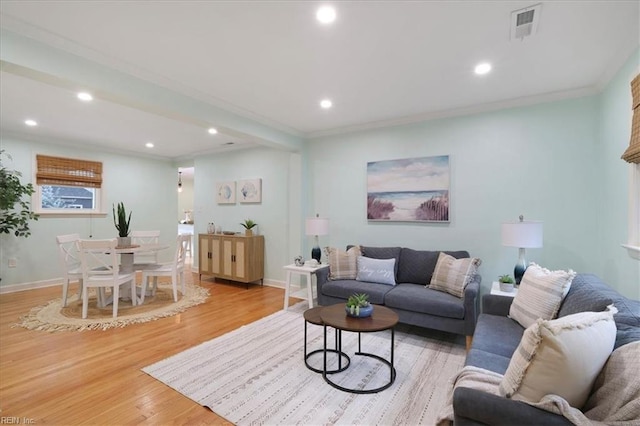 living room featuring crown molding and light hardwood / wood-style floors