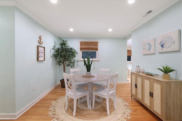 dining room featuring crown molding and light hardwood / wood-style floors