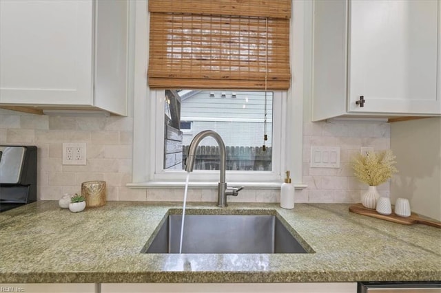 kitchen with white cabinetry, sink, backsplash, and light stone counters