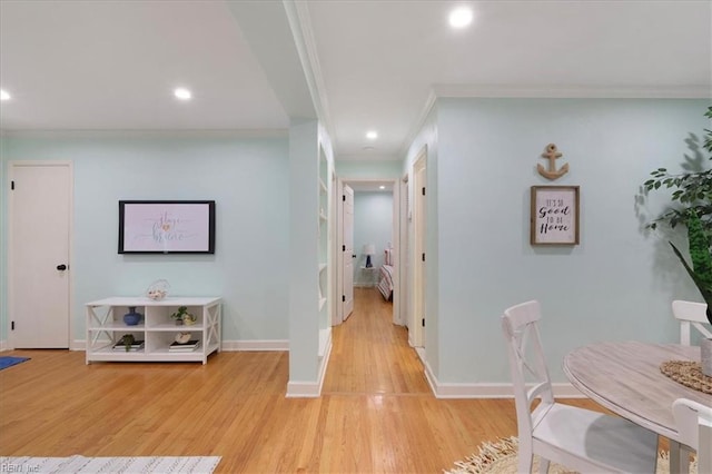 hallway featuring crown molding and light hardwood / wood-style floors