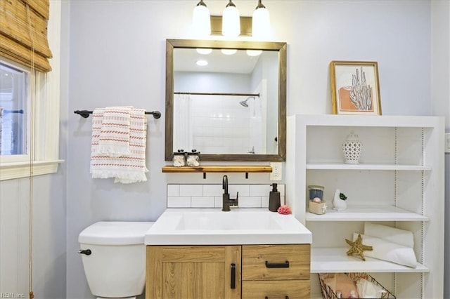 bathroom featuring tasteful backsplash, vanity, a shower with curtain, and toilet