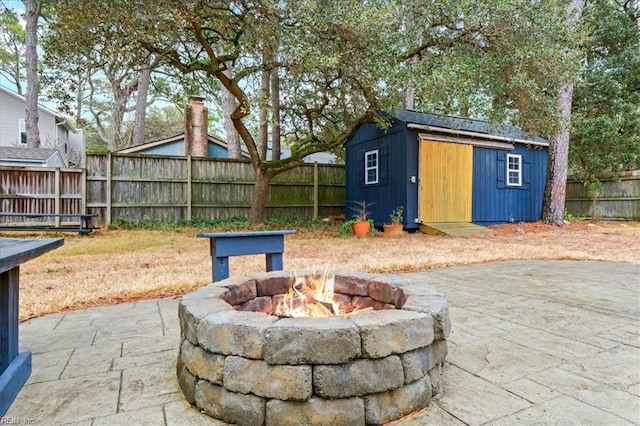 view of patio featuring a storage shed and a fire pit