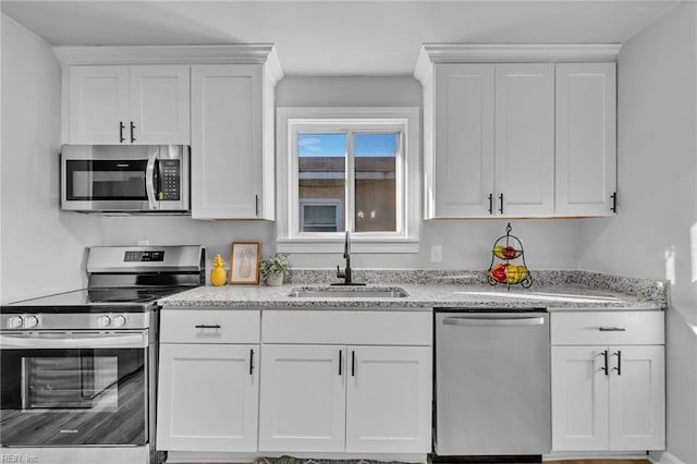 kitchen featuring white cabinetry, sink, stainless steel appliances, and light stone countertops