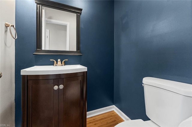 bathroom featuring vanity, toilet, and hardwood / wood-style floors