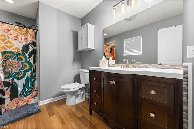 bathroom with vanity, a textured ceiling, wood-type flooring, and toilet