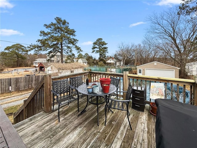 wooden deck featuring an outbuilding and a garage