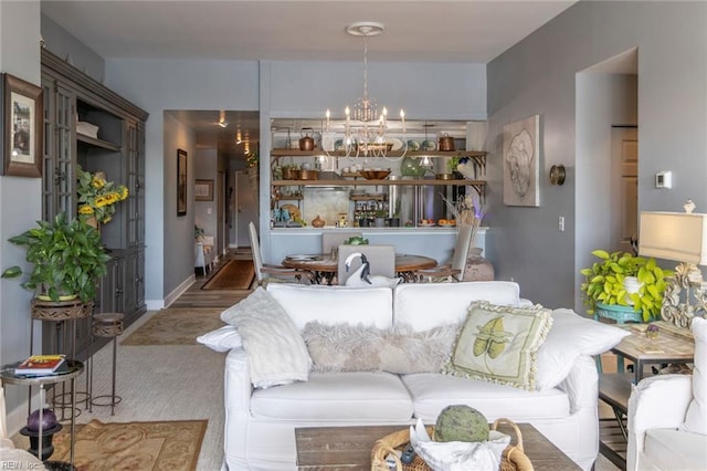 living area featuring baseboards and an inviting chandelier