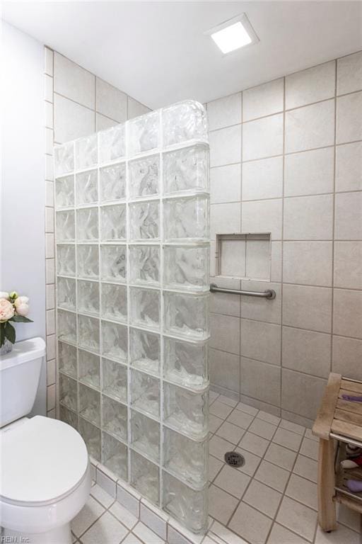 full bathroom featuring tile patterned floors, toilet, and a walk in shower