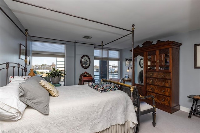 bedroom with baseboards, visible vents, and light colored carpet