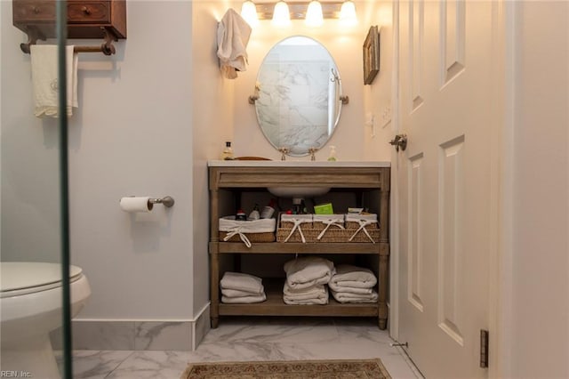 bathroom featuring marble finish floor, toilet, and baseboards