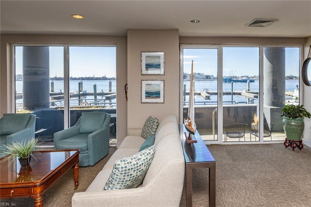 living area featuring a water view, visible vents, and carpet flooring